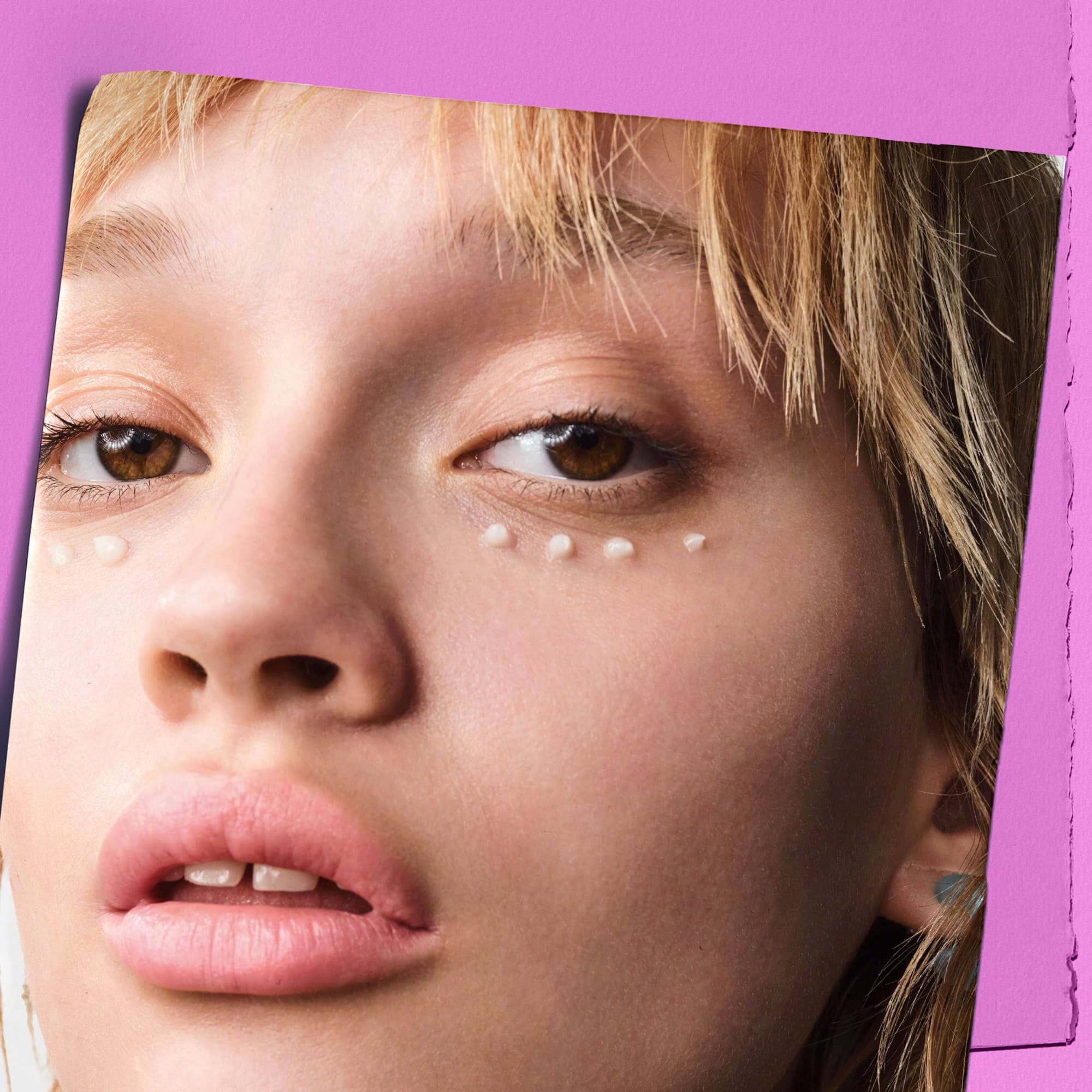 Model mit Tupfern der Kiehl's Super Multi-Corrective Eye Zone Treatment unter den Augen