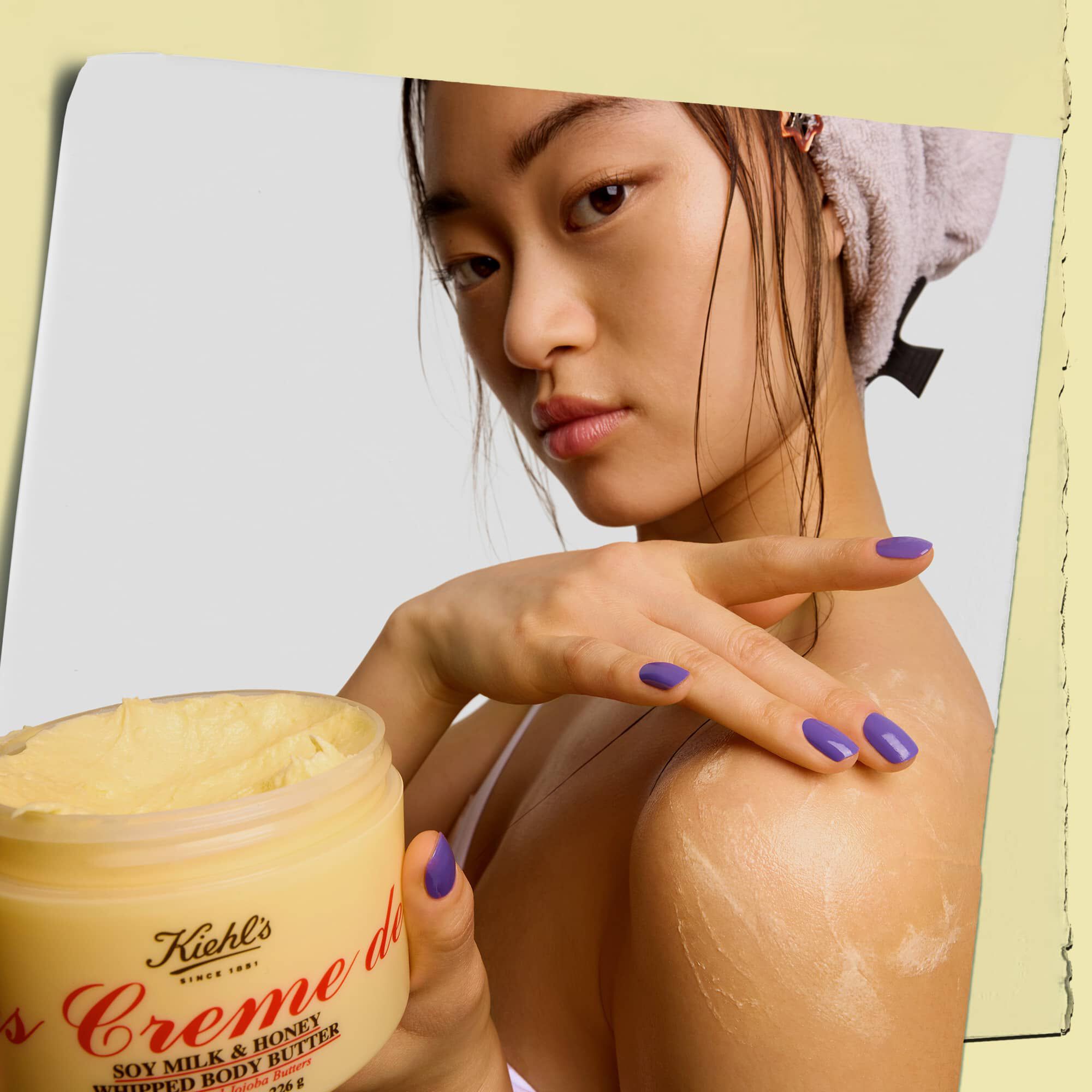 Model halt einen Tiegel der Kiehl's Creme de Corps Whipped Body Butter