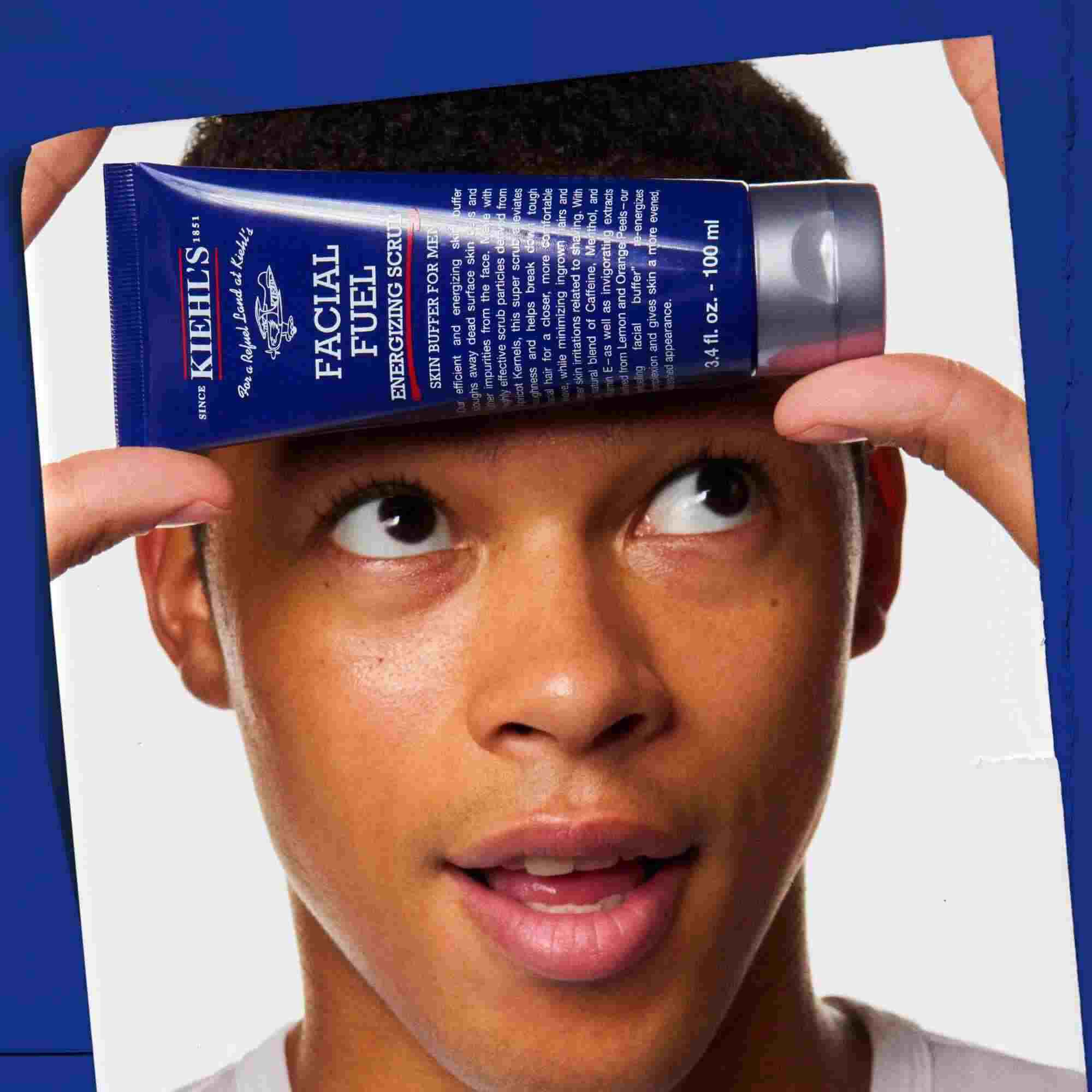 Facial Fuel Energizing Scrub in der Hand gehalten, zeigt die Anwendung.