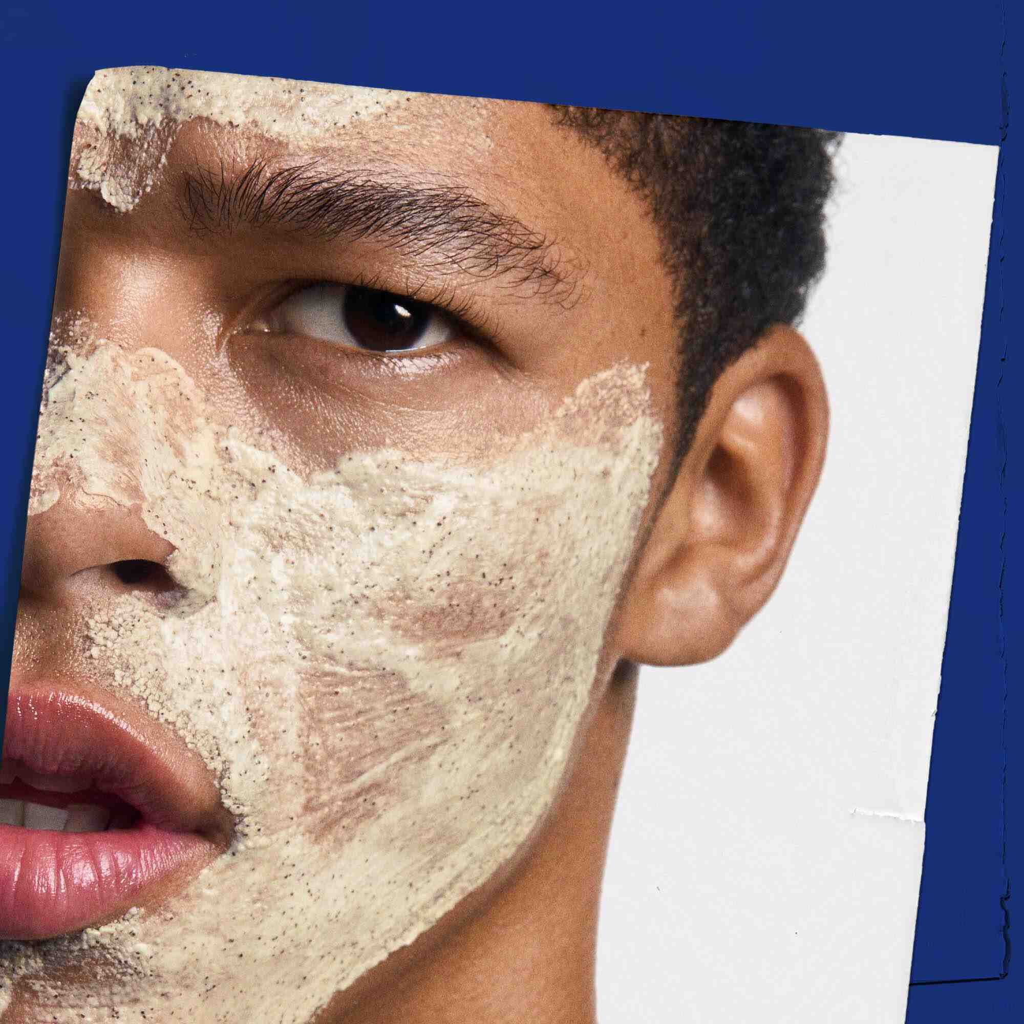 Facial Fuel Energizing Scrub auf das Gesicht aufgetragen, zeigt die Anwendung.