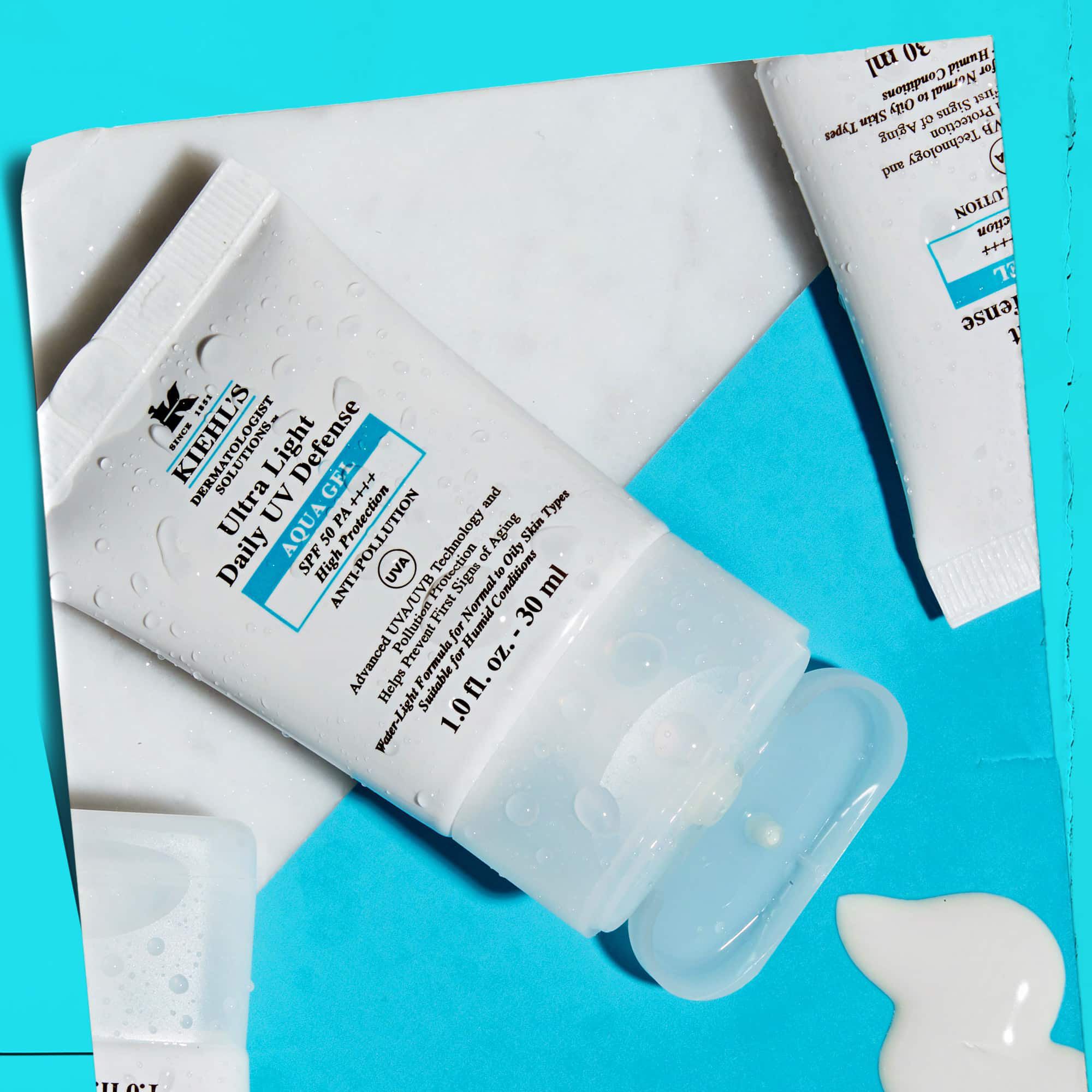 Ein Flatlay mehrerer Ultra Light Daily UV Defense Aqua Gel Tuben auf einer Marmoroberflache, das ihren Lifestyle-Charakter zeigt.