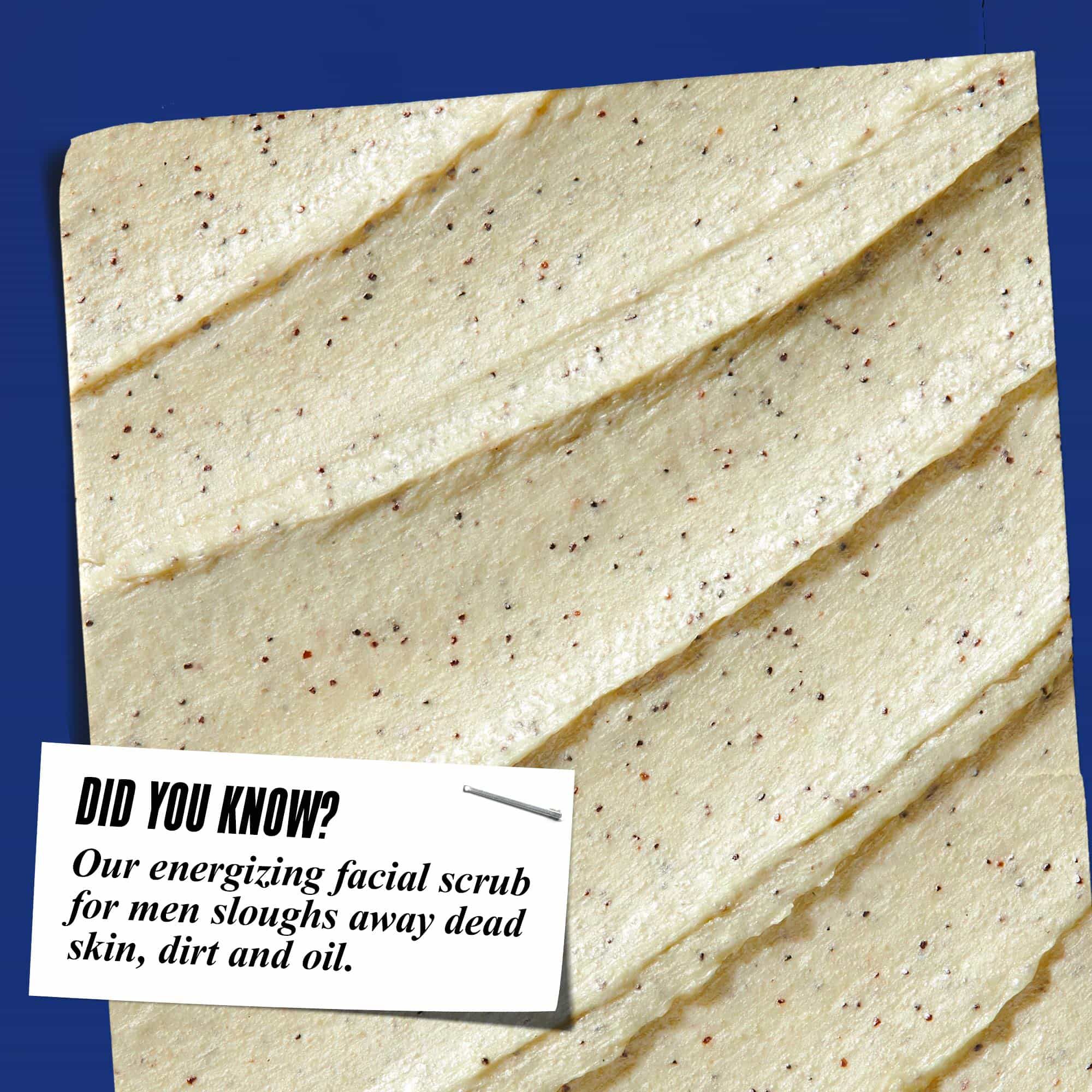 Nahaufnahme der Textur von Facial Fuel Energizing Scrub. Der Text lautet: „Wussten Sie schon? Unser belebendes Gesichtspeeling fur Manner entfernt abgestorbene Hautschuppchen, Schmutz und uberschussiges Ol.“