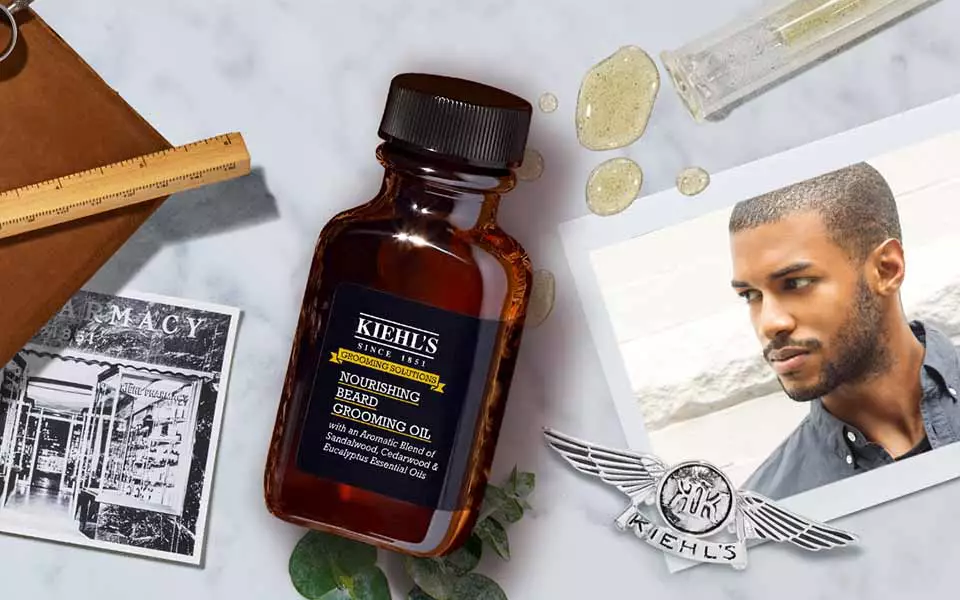 Alt-Text: Ein flacher Bildausschnitt mit einem Shampoo-Produkt, einem Foto eines Mannes, und verschiedenen Gegenstanden wie einem Holzlineal und Steinchen auf einer marmorartigen Oberflache.