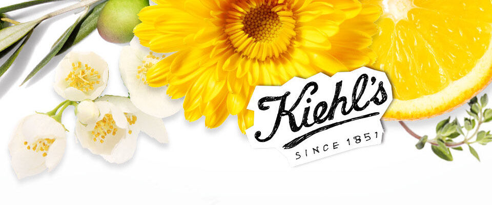 Eine stilisierte Anordnung von Blumen, einer Orange und Olivenzweigen, begleitet von dem Kiehl's Logo.