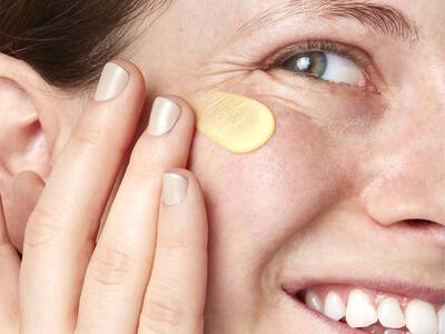 Aufgetragenes Pflegeprodukt gegen Krahenfuße unter den Augen