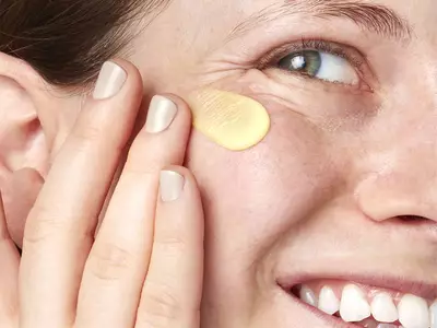 Aufgetragenes Pflegeprodukt gegen Krahenfuße unter den Augen