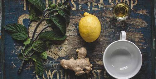 Ingwer mit Zitrone und Minze neben einer Tasse