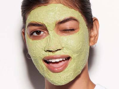 Frau mit gruner Gesichtsmaske als Hausmittel gegen Krahenfuße