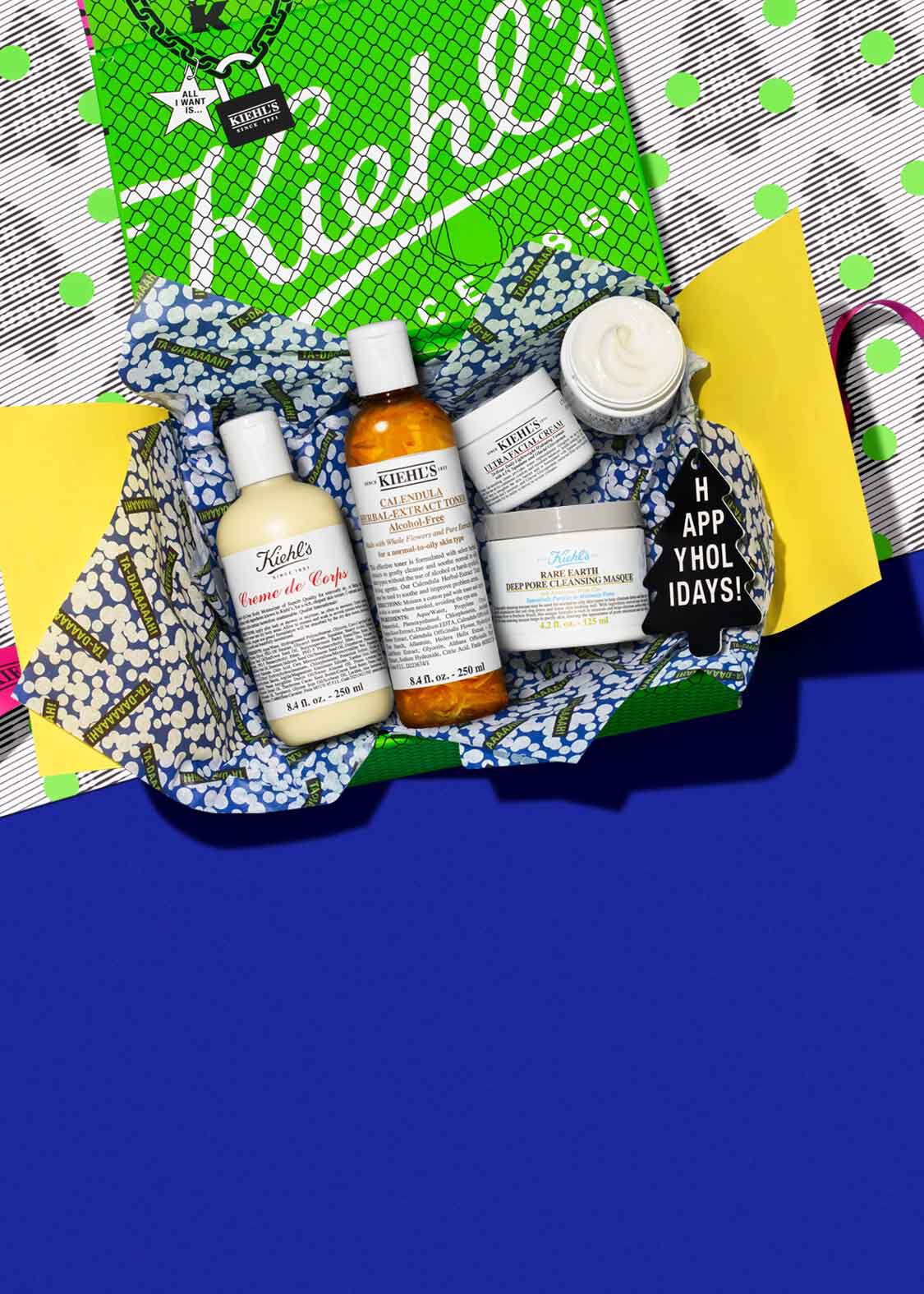 Ein Geschenkpaket mit verschiedenen Kiehl's Produkten auf einem bunten Hintergrund.