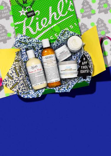 Ein Geschenkpaket mit verschiedenen Kiehl's Produkten auf einem bunten Hintergrund.