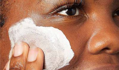 Frau mit Creme auf der Wange