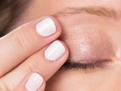 Frau schließt ihr Auge und versteckt Krahenfuße 