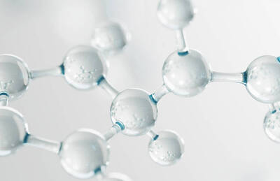 Close-up of transparent molecular structures composed of spheres connected by thin lines, set against a soft, blurred background.