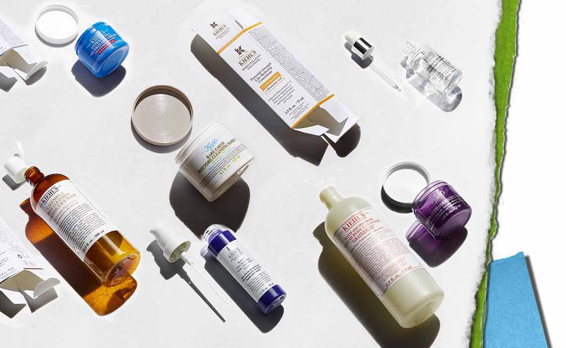 Eine Auswahl an Hautpflegeprodukten auf hellem Hintergrund, darunter Flaschen, Tiegel und Pipetten in verschiedenen Farben und Formen.